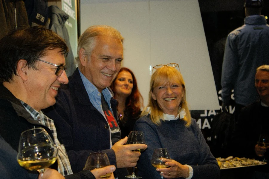 Des invités rient ensemble devant les vestes Helly Hansen