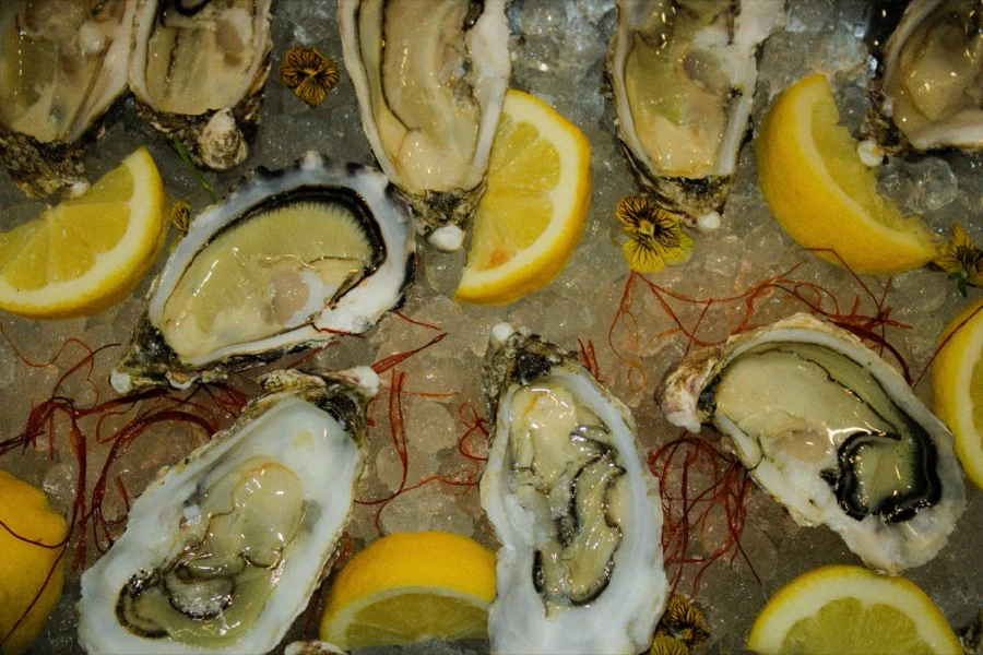 Huîtres sur glace pilée, citrons et fils de piment, vues de dessus