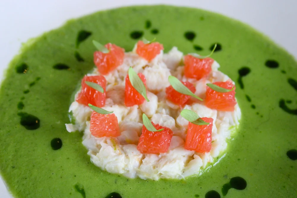 Crabe et pamplemousse sur velouté vert, en gros plan