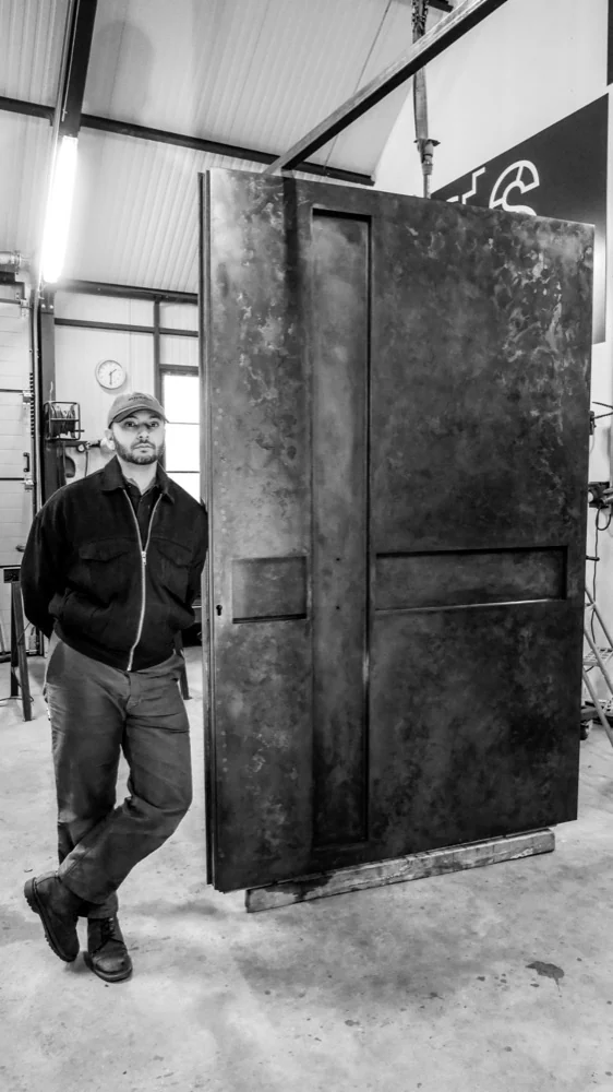 L’architecte à côté d’une porte en métal patiné