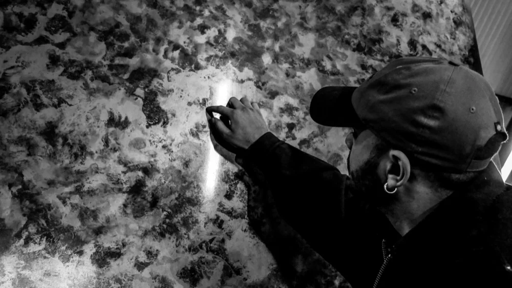 La main sur une patine, dans un reflet de lumière